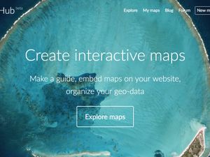 A screenshot of the MapHub homepage, featuring the tagline 'Create interactive maps' over a vibrant satellite image of a tropical atoll, representing the updated mapping tool. by a completely rewritten platform for creating interactive maps.'