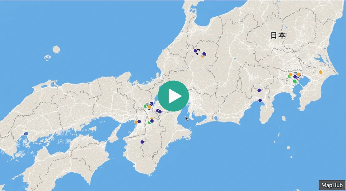 A map of Japan with various colored markers, centered with a large green play button icon, demonstrating the loading animation of a MapHub HD embed.