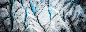 A detailed, close-up photograph of a glacier's surface, showing sharp white peaks, vibrant blue ice in deep crevasses, and layers of dark sediment. clear and transparent commitment to GDPR compliance.